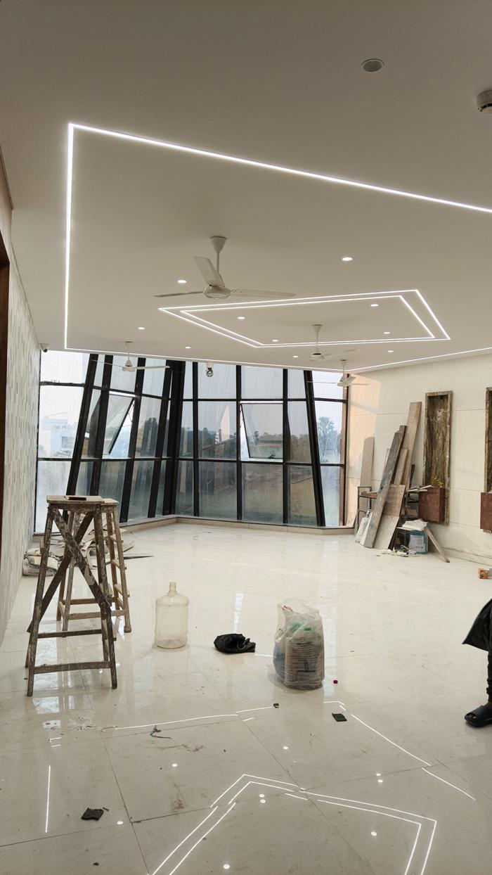 Large hall with smooth white ceiling and walls during finishing work